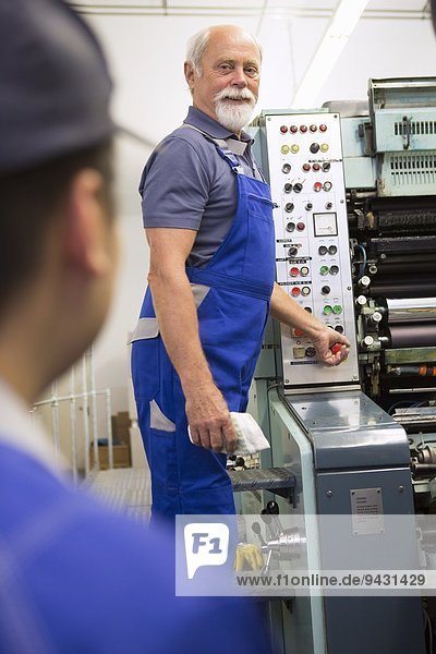 Factory worker at control panel of machinery