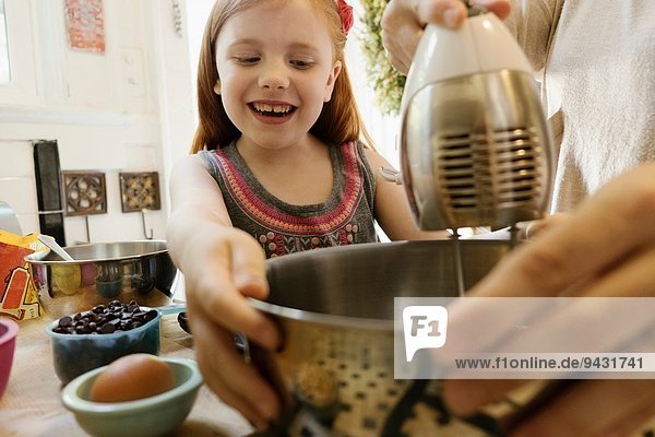 Girl giving mother a helping hand in kitchen