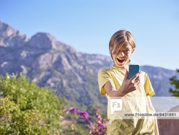 Junge macht Gesicht für Selfie auf Smartphone  Mallorca  Spanien