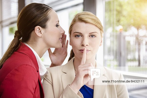 Businesswomen sharing secret