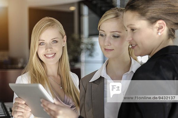 Geschäftsfrauen tauschen Informationen auf digitalen Tabletts aus