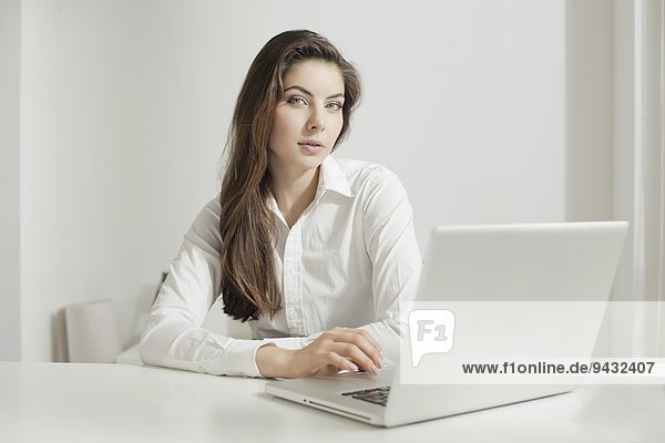 Junge Frau bei der Arbeit am Laptop