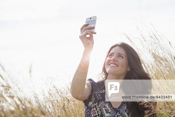 Junge Frau nimmt Selfie mit Smartphone im Einsatz