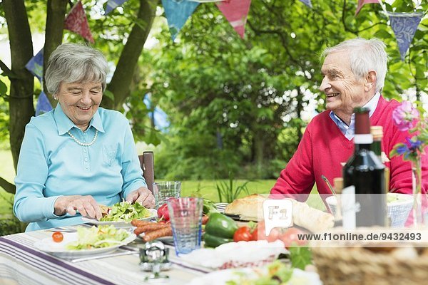 Seniorenpaar beim Mittagessen im Freien