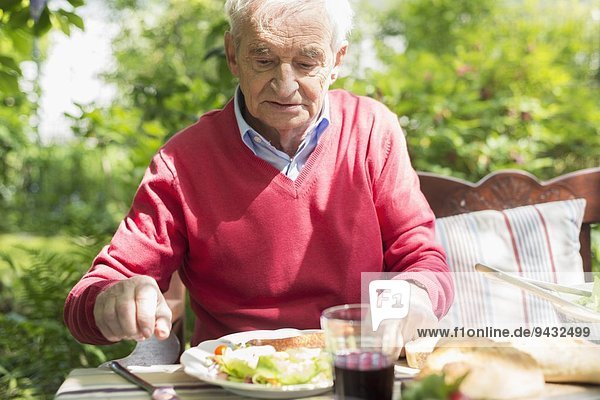 Senior man having lunch outdoors