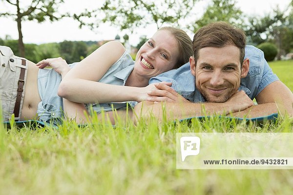 Mittleres erwachsenes Paar auf Gras liegend