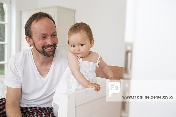 Father smiling at baby daughter