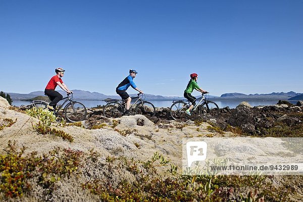 Radfahrer im Thingvellir Nationalpark mit Thingvallavatn und Langjokull im Hintergrund Nesjavellir Island