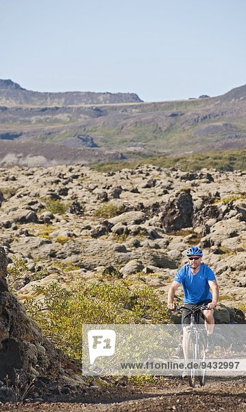 Mature man cycling Nesjavellir Thingvellir national park Iceland