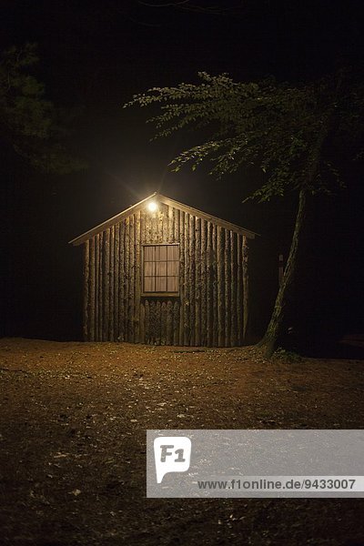 Wooden shed with electric light at night