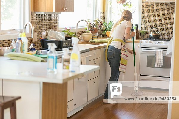 Young woman mopping with green cleaning products