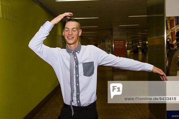 Porträt eines jungen Mannes  der in der U-Bahn-Station tanzt.