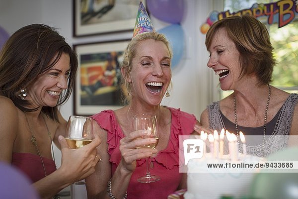 Drei reife Frauen bei der Geburtstagsfeier  lachend
