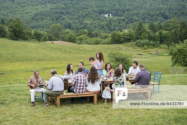 Family having meal together and socialising  outdoors
