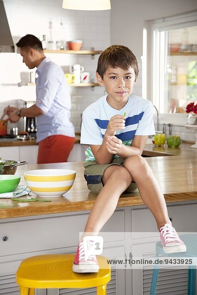 Boy sitting on kitchen counter