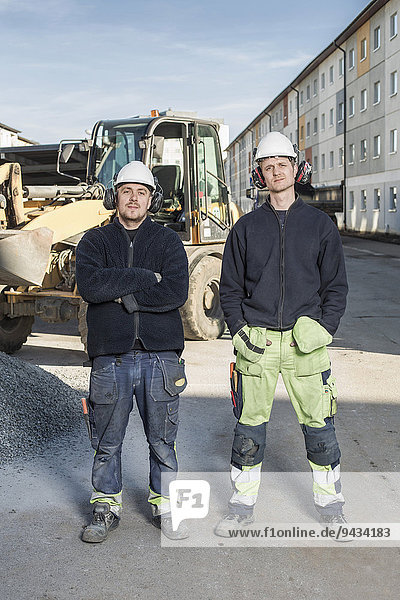 Vollständiges Porträt der selbstbewussten Arbeiter auf der Baustelle