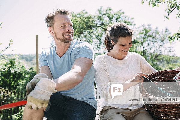 Ein glückliches Paar entspannt sich bei der Gartenarbeit auf dem Hof