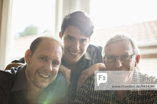 Porträt einer Drei-Generationen-Familie  die zu Hause zusammen lächelt