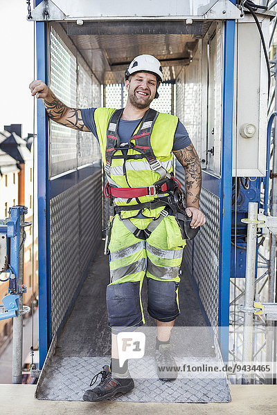 Porträt eines lächelnden Arbeiters in Arbeitsschutzbekleidung auf der Baustelle