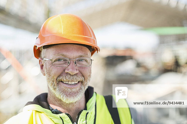 Porträt eines glücklichen Bauarbeiters auf der Baustelle