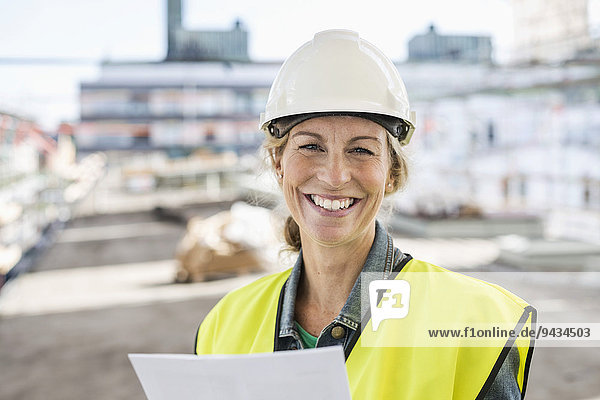 Portrait of happy female architect at construction site