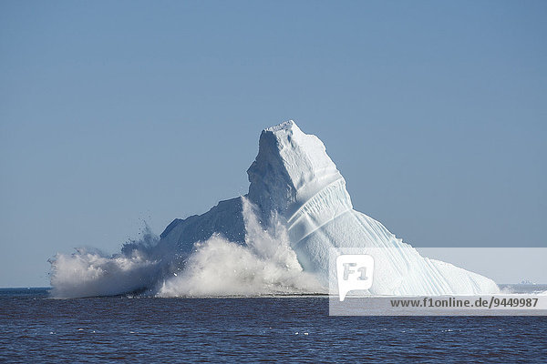 Eismassen brechen von einem enormen Eisberg ab  so dass er aus dem Gleichgewicht gerät und kollabiert  Qeqertarsuaq  Diskobucht  Grönland