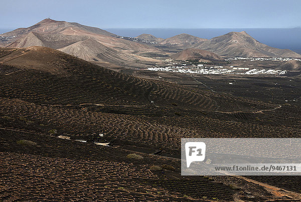Ausblick von der Kette Montaña de Guardilama nach Süden auf das Weinanbaugebiet La Geria  hinten Uga und Yaiza  links Vulkanberg Atalaya de Femès  rechts El Rubicon  Lanzarote  Kanarische Inseln  Spanien  Europa