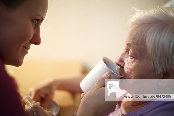 Frau  85 Jahre  im Altersheim  beim Frühstück  unterstützt durch Altenpflegerin  Kralovske Porici  Böhmen  Tschechische Republik