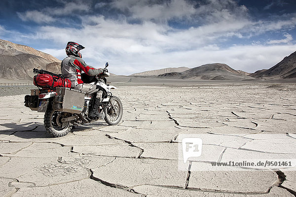 Motorcyclist travelling on the Pamir Highway  M41  Province of Gorno-Badakhshan  Tajikistan  Asia
