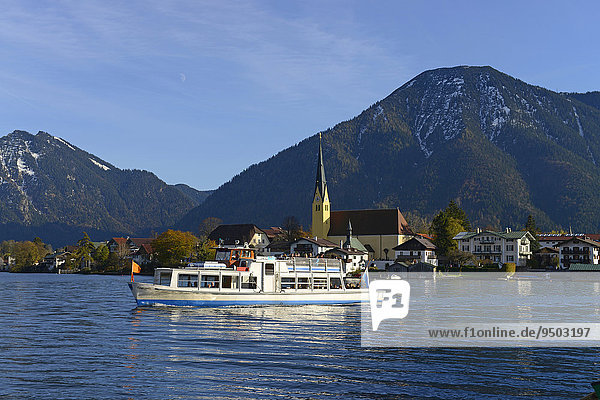 Parish Church of St. Lawrence and motorboat in front of Bodenschneid  Stümpfling and Wallberg mountains  lake Tegernsee  Egern  Rottach-Egern  Upper Bavaria  Bavaria  Germany  Europe