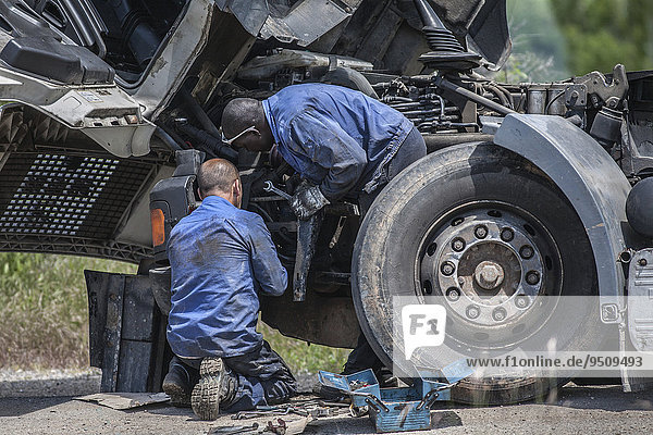 Two men repairing a truck  Mozambique  Africa