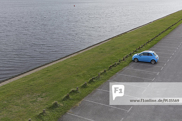 Einzelnes Auto  Fiat 500  parkt auf einem leeren Parkplatz an einem Binnengewässer  Halbinsel Walcheren  Zeeland  Niederlande  Europa