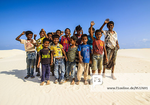 Young Socotrian boys posing in the sand dunes at the south coast of the island of Socotra  Yemen  Asia