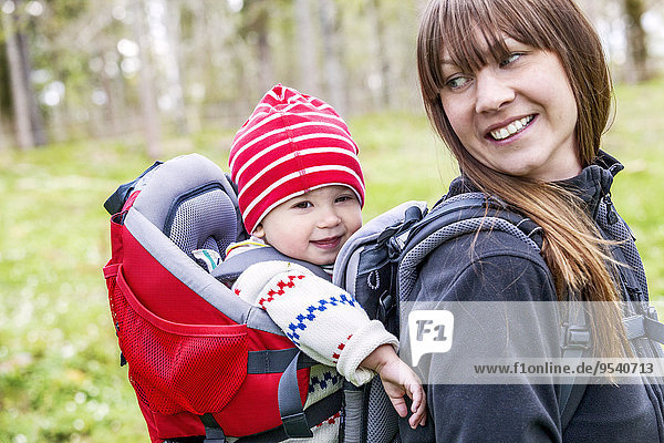 Smiling woman with baby in baby carrier
