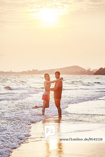 Young couple on beach at dusk