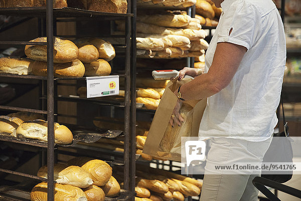 Senior Senioren Frau Brot kaufen