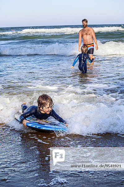 Father with sons surfing