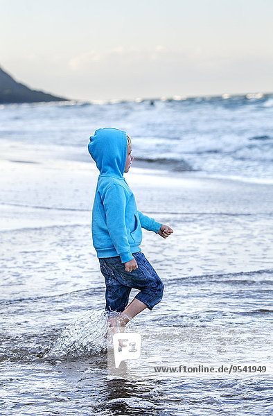Boy wearing hoodie on beach