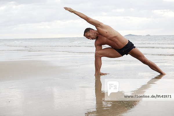 Mann Strand üben Yoga