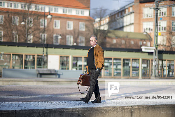 Senior Senioren Mann gehen Haltestelle Haltepunkt Station Zug