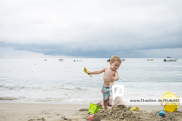 Mexiko  Kleinkind spielt am Strand am Meer