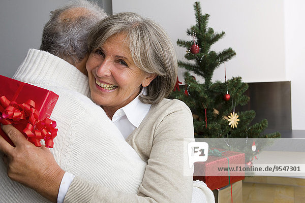 Seniorenpaar tauscht zu Hause Weihnachtsgeschenke aus