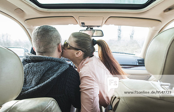 Woman kissing man in car
