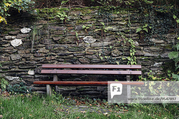 Bench in front of natural stone wall