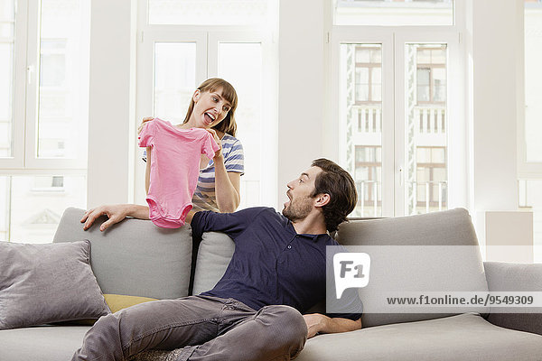 Expectant parents with pink baby shirt