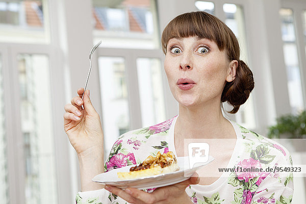 Lächelnde Frau genießt ein Stück Kuchen