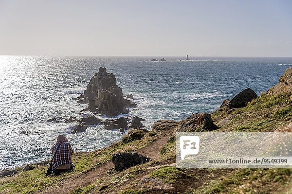 Großbritannien  England  Cornwall  Land's End  Fotograf beim Fotografieren von Armed Knight und Wols Rock Lighthouse