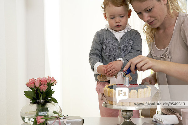 Mother and daughter celebrating little girl's first birthday with self-made fancy cake