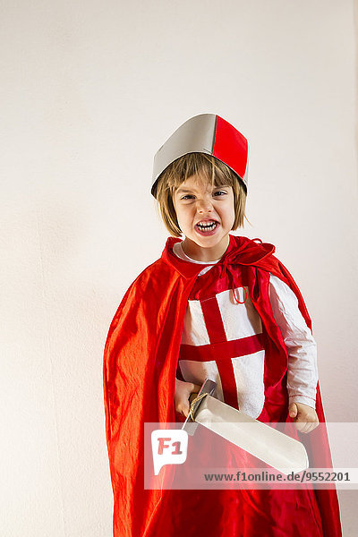 Portrait of little girl masquerade as a knight making a face