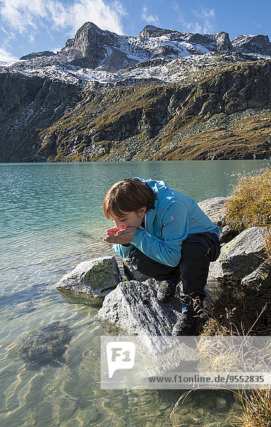 Austria  Salzburg State  Pinzgau  woman at drinking water from Weisssee mountain lake